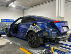 Honda Civic undergoing collision repair on a Car-O-Liner frame machine at CarVive Collision Centers