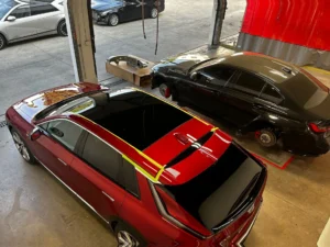 Two vehicles undergoing collision repair inside a body shop, showing poor repair practices and inspection areas